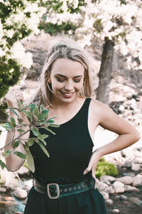 Young woman standing against plants