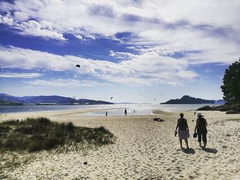 People on beach against sky