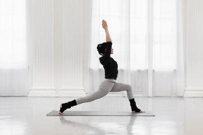 Full length of woman exercising on floor