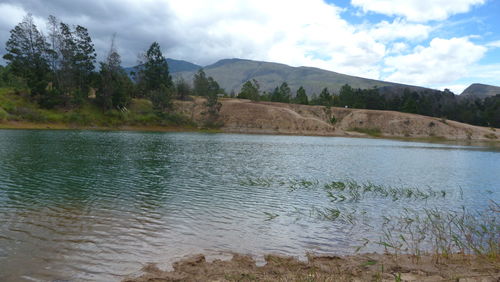 Scenic view of lake by mountains against sky