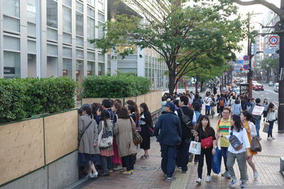 People walking on street amidst buildings in city