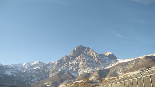 Scenic view of snowcapped mountains against clear blue sky