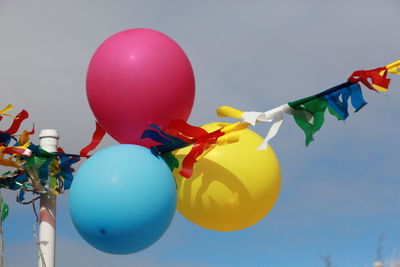 Low angle view of balloons against blue sky