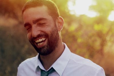 Happy businessman laughing during sunset