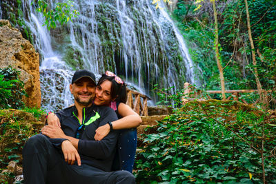 Portrait of smiling young man and woman in forest  