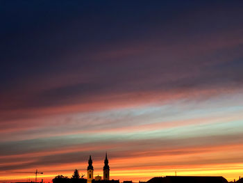 Silhouette of building against dramatic sky during sunset