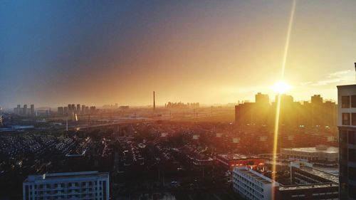 Sun shining through clouds over city