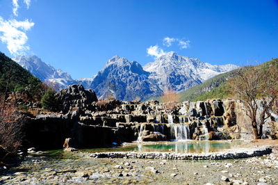 Scenic view of snowcapped mountains against blue sky