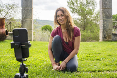 Portrait of smiling woman sitting on grass