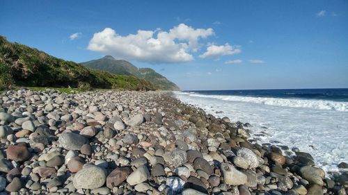 Rocks on beach against sky
