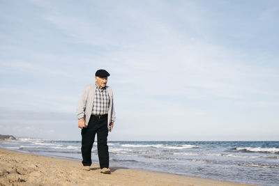 Senior man strolling on the beach in spring