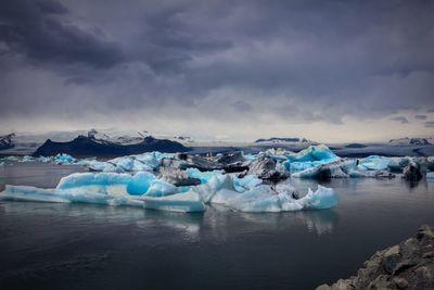 Scenic view of frozen lake against cloudy sky