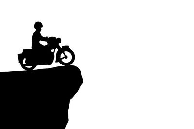 Silhouette man riding bicycle against white background