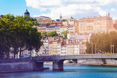 Arch bridge over river against buildings in city