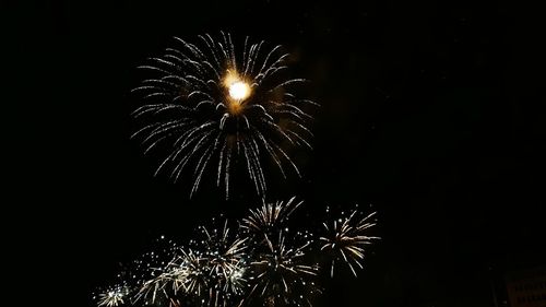 Low angle view of firework display at night
