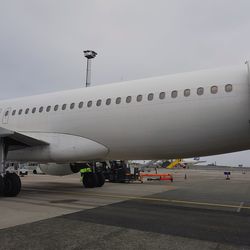 Airplane on airport runway against sky