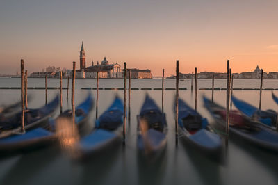 Gondolas moored in canal during sunset