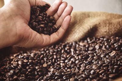 Cropped image of hand holding coffee beans