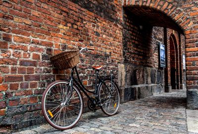 Parked bicycle against brick wall