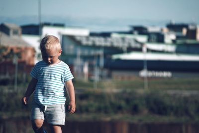 Rear view of boy standing outdoors