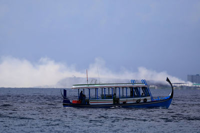 Ship sailing in sea against sky