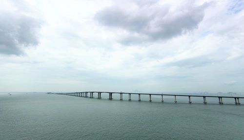 Bridge over calm sea against sky