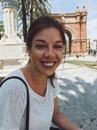 Happy young woman against arc de triomf