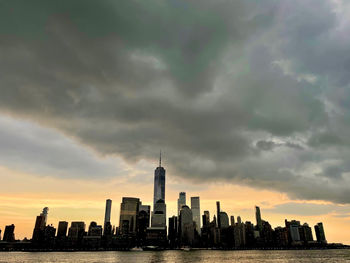 Buildings in city against cloudy sky