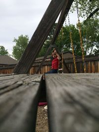 Woman standing on wooden wall