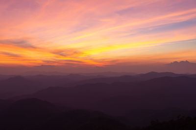 Scenic view of silhouette mountains against romantic sky at sunset