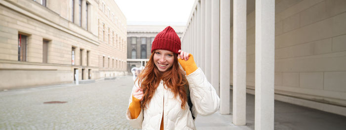 Side view of woman standing against building