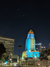 Low angle view of illuminated buildings against sky at night