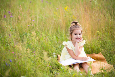 Portrait of a smiling girl sitting on field