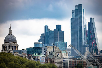 Buildings in city against cloudy sky