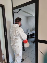 Rear view of man standing against door