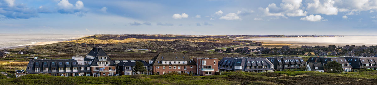 Panoramic view of sea and buildings against sky