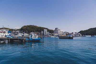 Sailboats moored in sea against clear sky