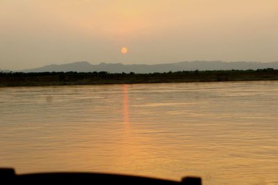 Scenic view of lake against sky at sunset