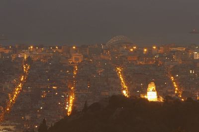 Illuminated cityscape against sky at night