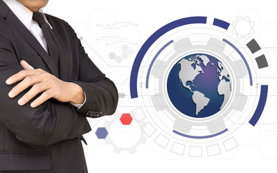 Digital composite image of businessman standing by globe against white background