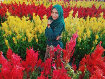 Full length of woman standing on red flowering plants