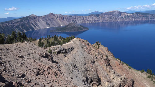 Panoramic view of lake and mountains against blue sky