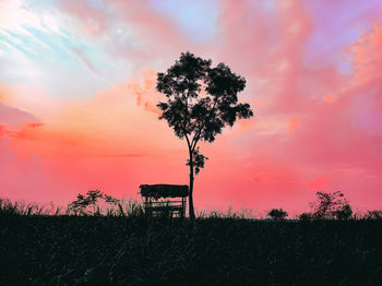 Silhouette tree on field against sky during sunset