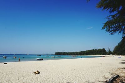 Scenic view of beach against clear blue sky