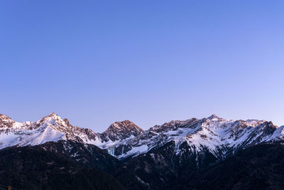 Scenic view of snowcapped mountains against clear blue sky