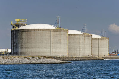 Three large concrete oil tanks on a sunny day at maasvlakte industrial area