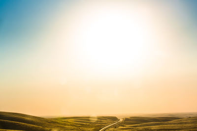 Scenic view of field against clear sky during sunset