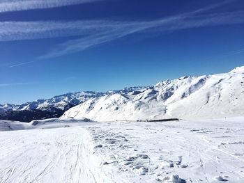 Scenic view of snow mountains against blue sky