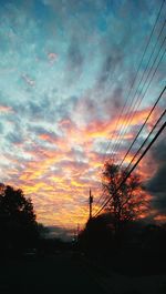 Silhouette of trees against cloudy sky