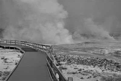 Bridge over geysers against sky